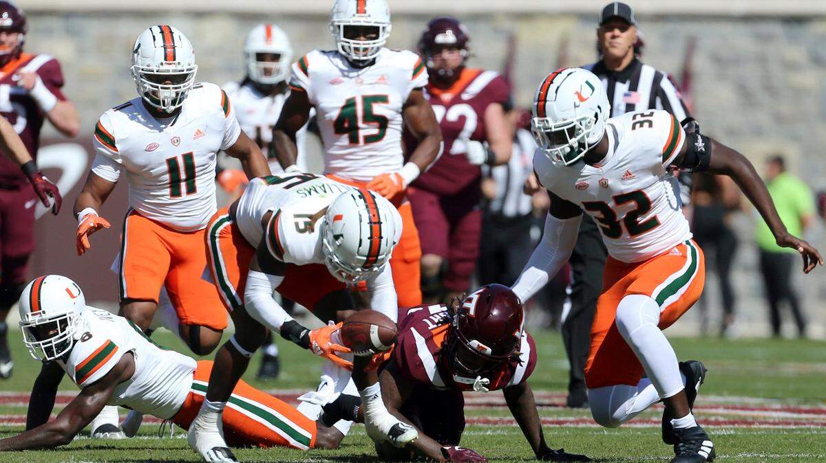 Miami’s Avantae Williams (15) scoops up a fumble by Virginia Tech’s Dae’Quan Wright (13) in the first half during the first half during the first half of an NCAA football game, Saturday Oct. 15 2022, in Blacksburg Va. (Matt Gentry/The Roanoke Times via AP)