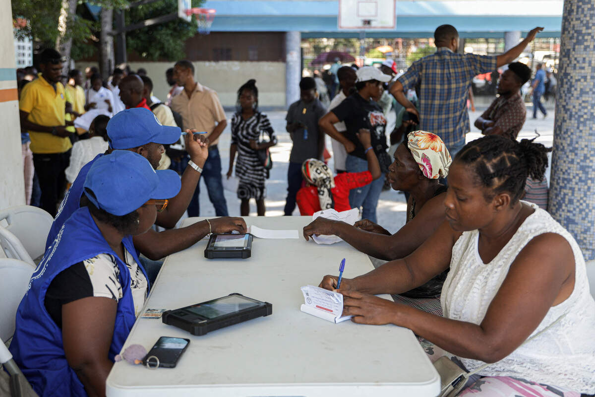 Electoral workers help people at a voter registration site ahead of Haiti's first presidential election in a decade, in Port-au-Prince, on Aug. 18, 2026.
