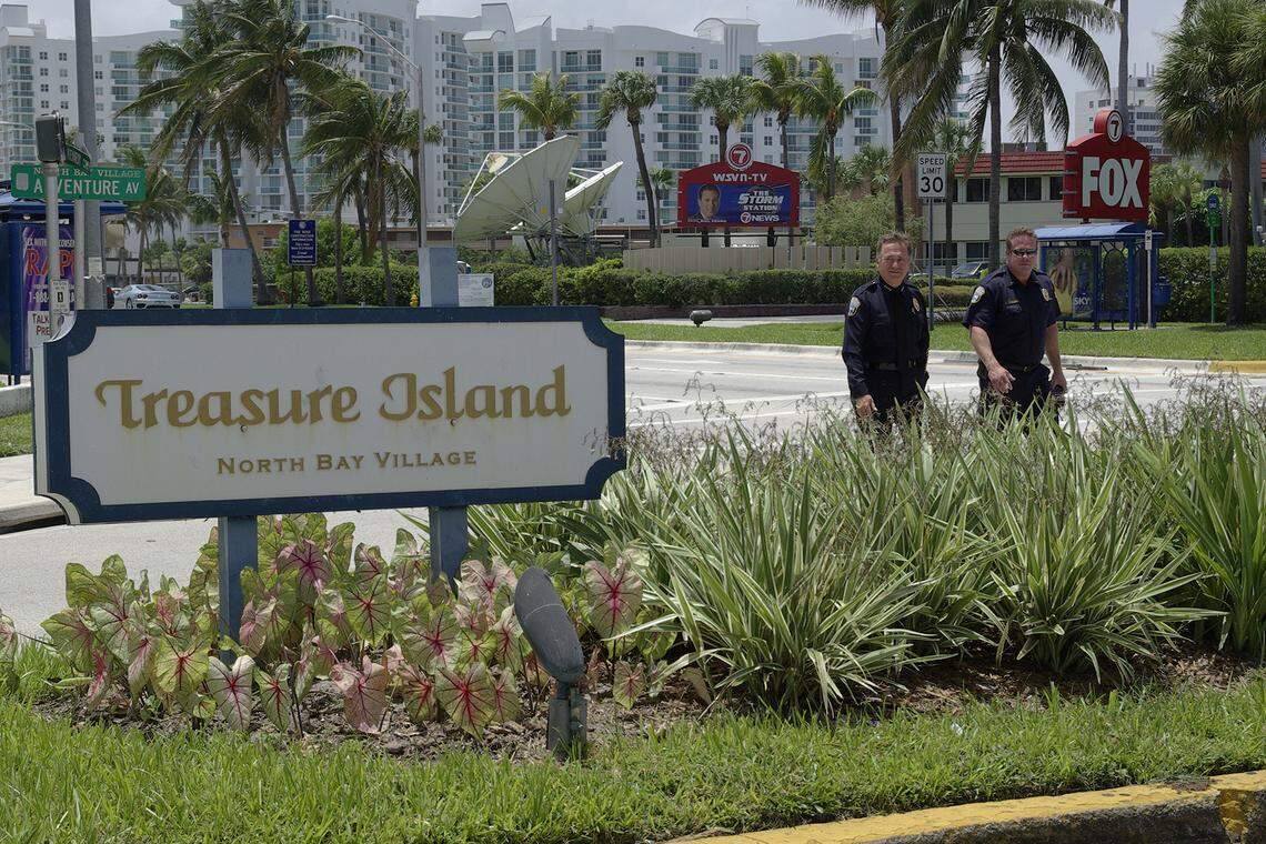 In 2010, then-newly appointed Police Chief Robert Daniels and Lt. James McVay, right, walk by the sign for the Treasure Island neighborhood as they talk about the new traffic cameras proposed in North Bay Village.