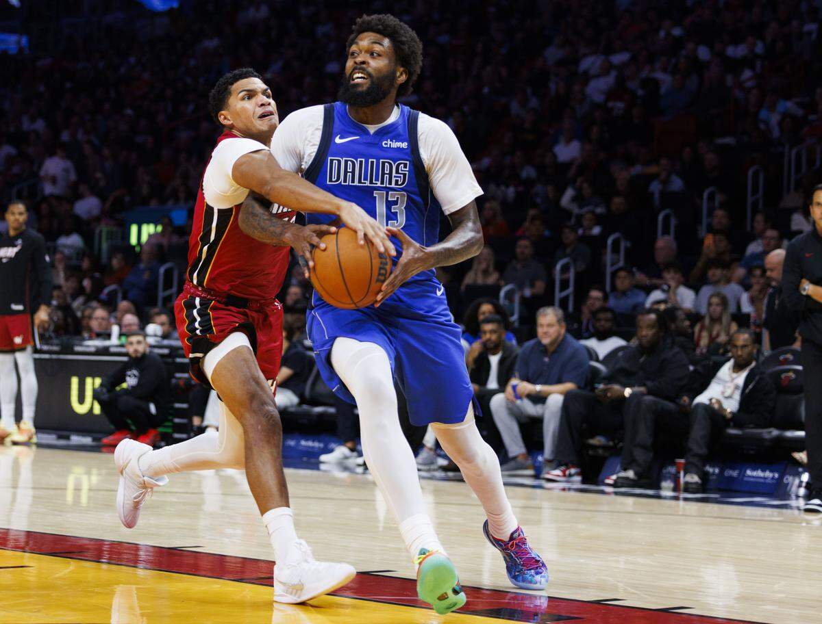 Miami Heat guard Dru Smith (12) reaches for the ball around Dallas Mavericks forward Naji Marshall (13) during the second half of a game on Nov. 24, 2025, at Kaseya Center in Miami.