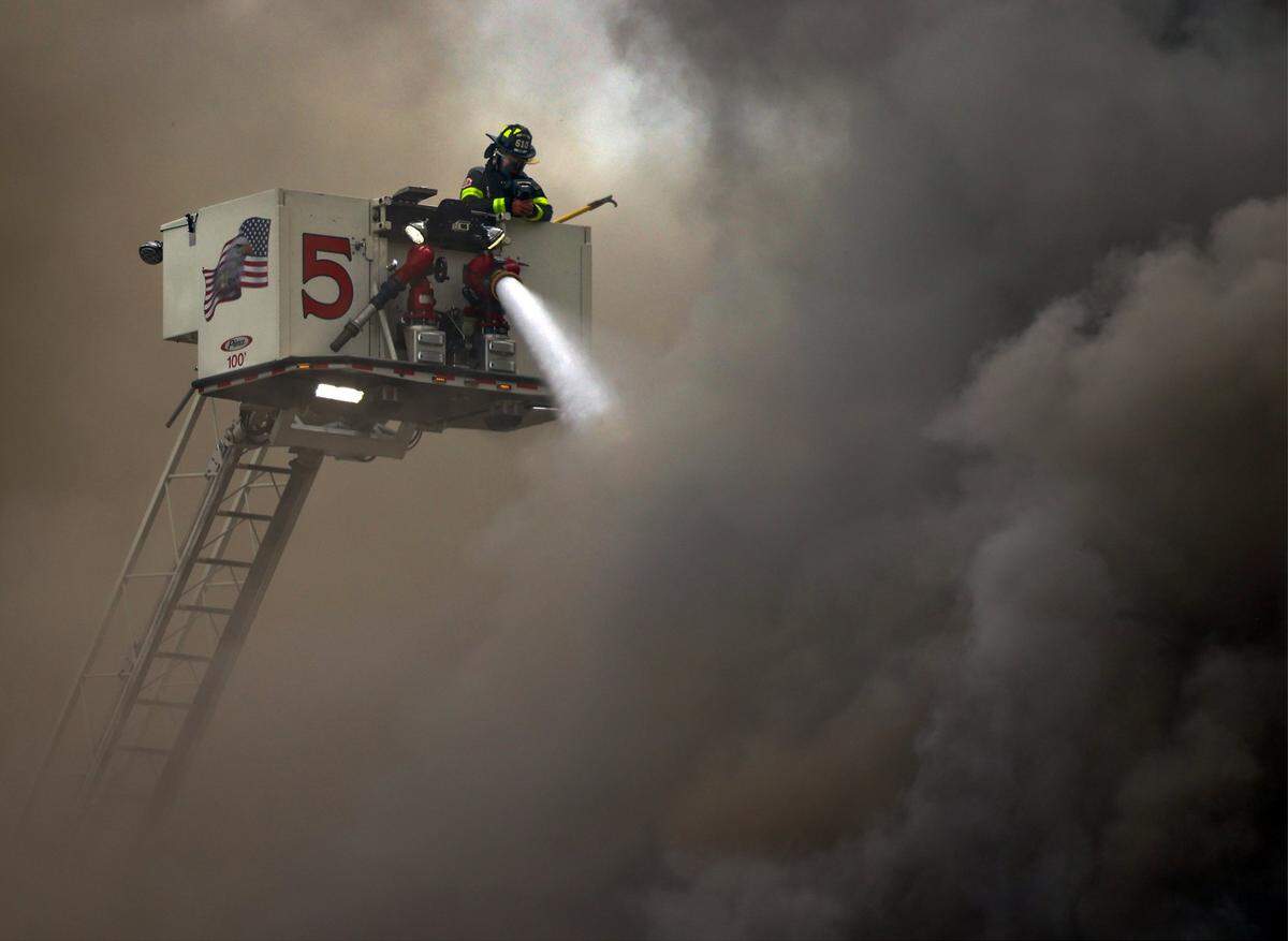 Firefighters from Station 5 spray water from its ladder truck onto the Temple Courts Apartments while responding to the 3-alarm fire. City of Miami Fire & Rescue with assistance from multiple stations battled the fire for several hours, preceded by a report of a shooting inside the Temple Court Apartments shortly after 8:15 a.m. on Monday, June 10, 2024, in Miami, Florida.