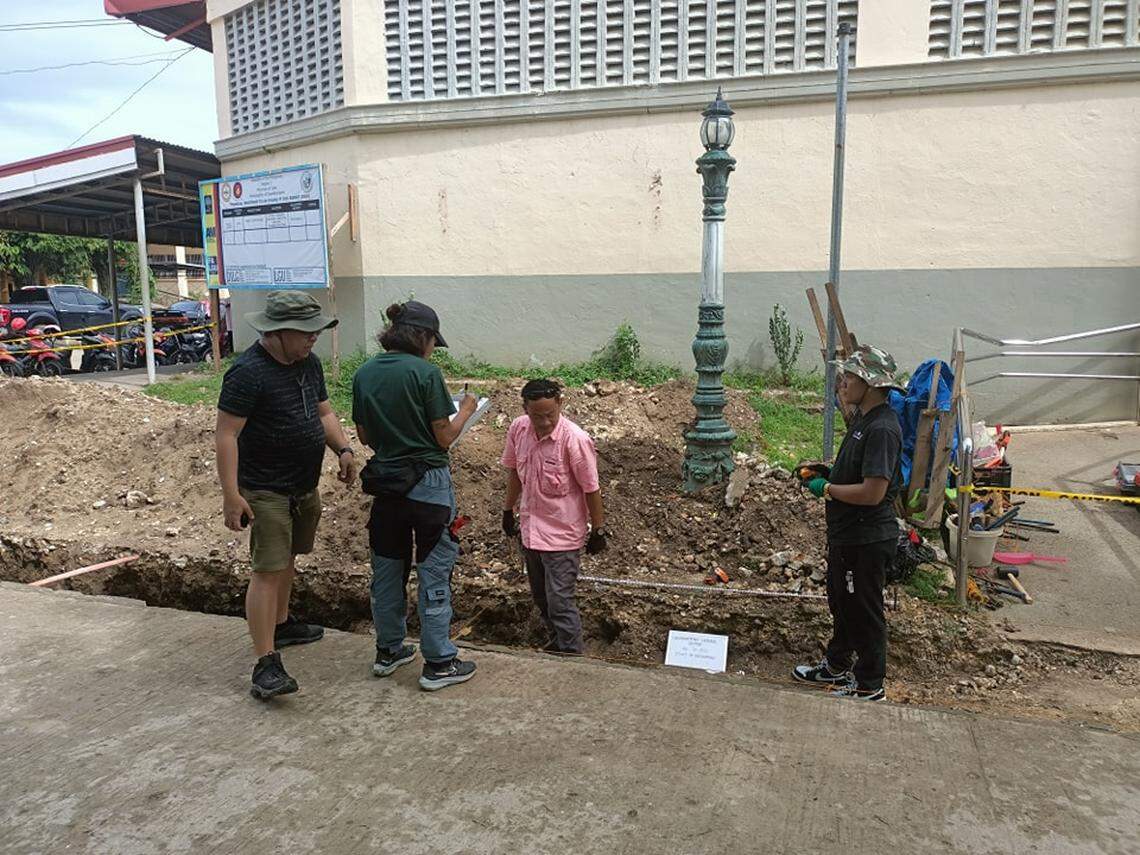People gather around the construction site turned archaeological excavation.
