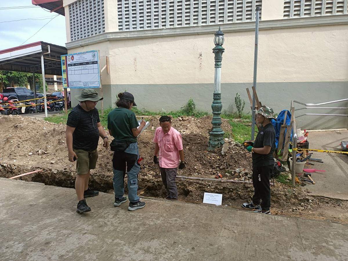 People gather around the construction site turned archaeological excavation.