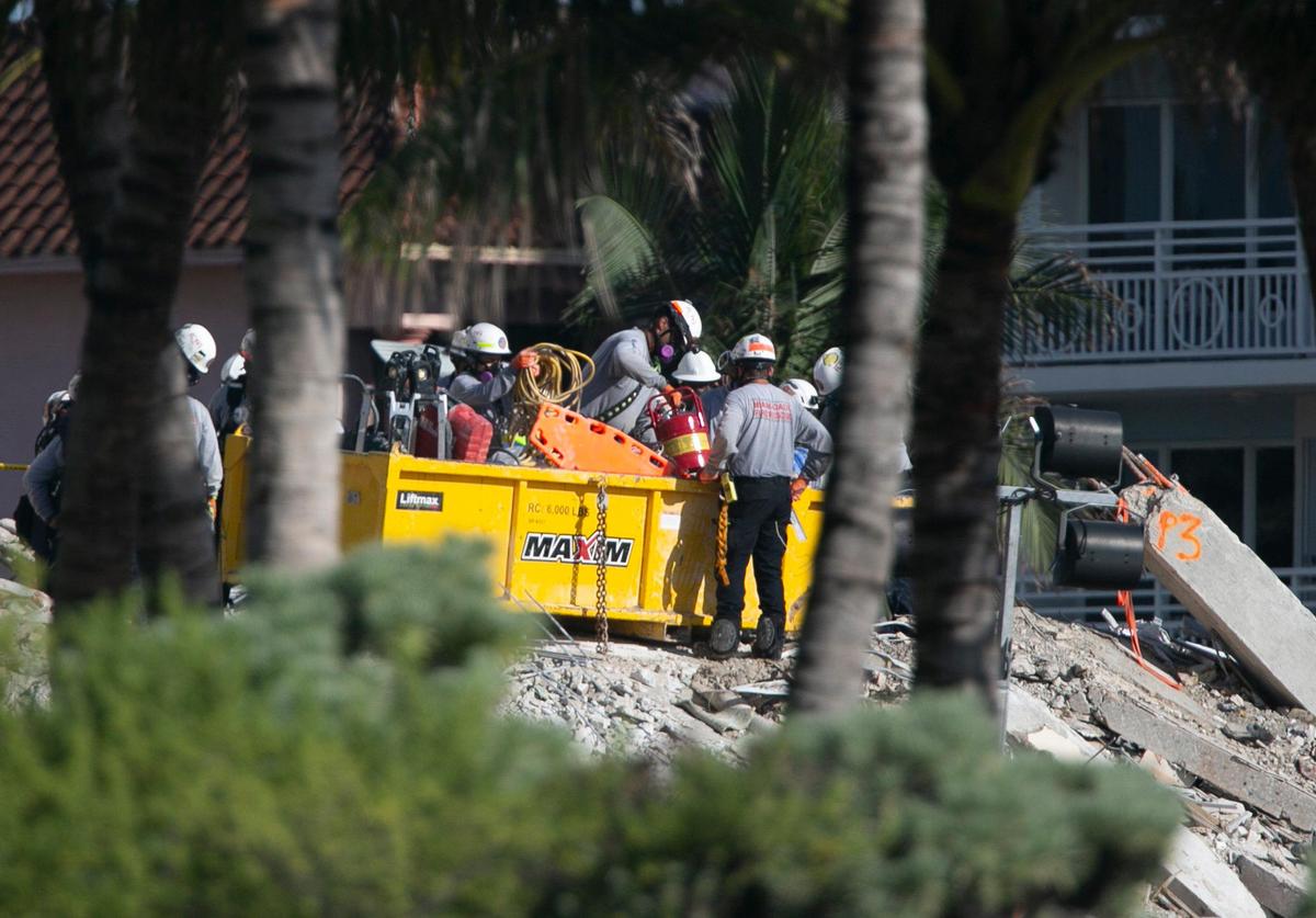 Search and rescue workers load gear and tools into a bin while working on the collapsed Champlain Towers South site Friday morning, July 2, 2021.