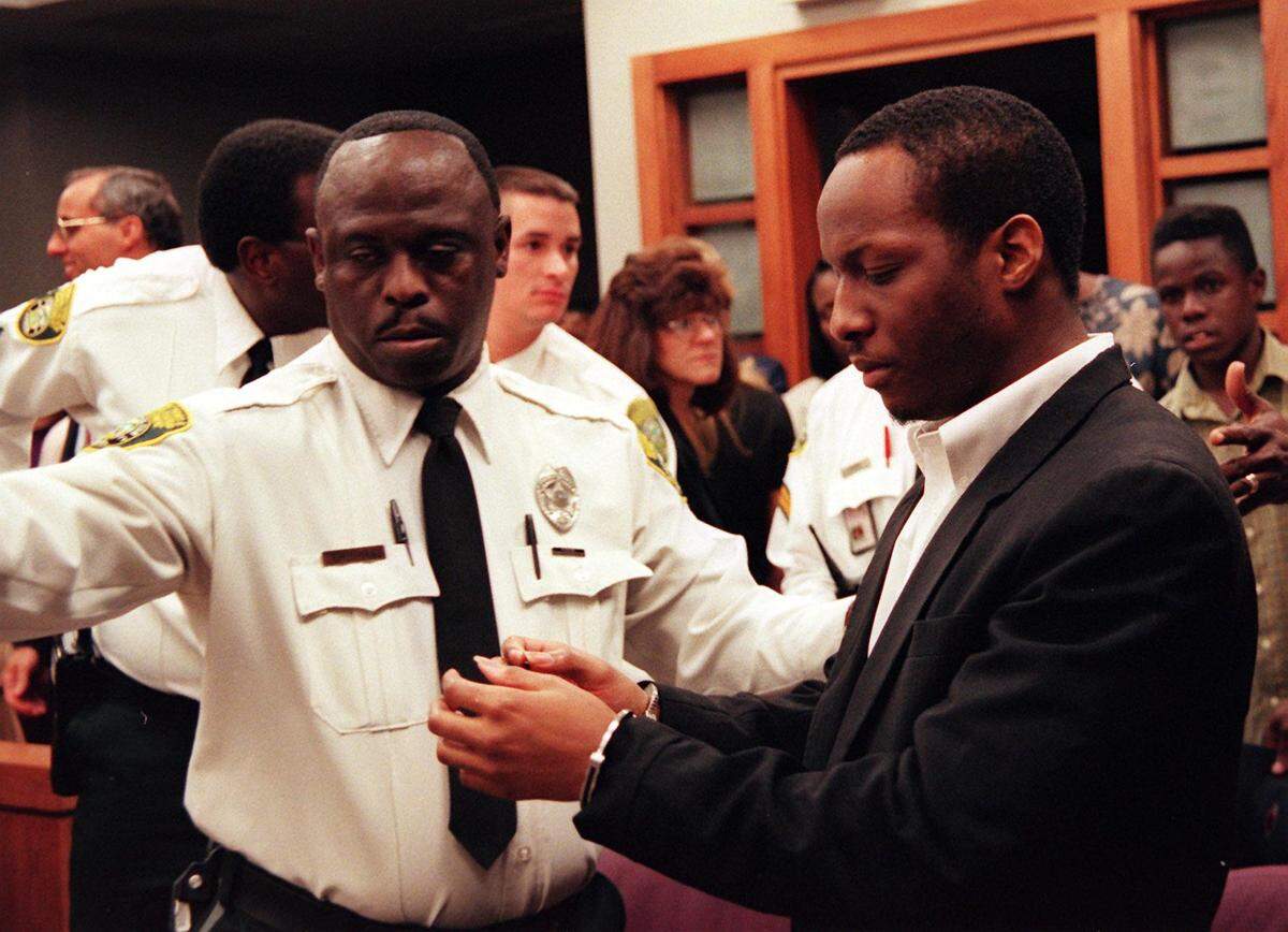 Labrant Dennis stares at the handcuffs while being led away after the reading of the jury's recommendation for the death penalty in this Herald file photo from 1998. He was convicted for the murders of Marlin Barnes and his friend Timwanika Lumpkins in their apartment on UM ‘s Coral Gables campus in 1996. Barnes was a football player for UM.