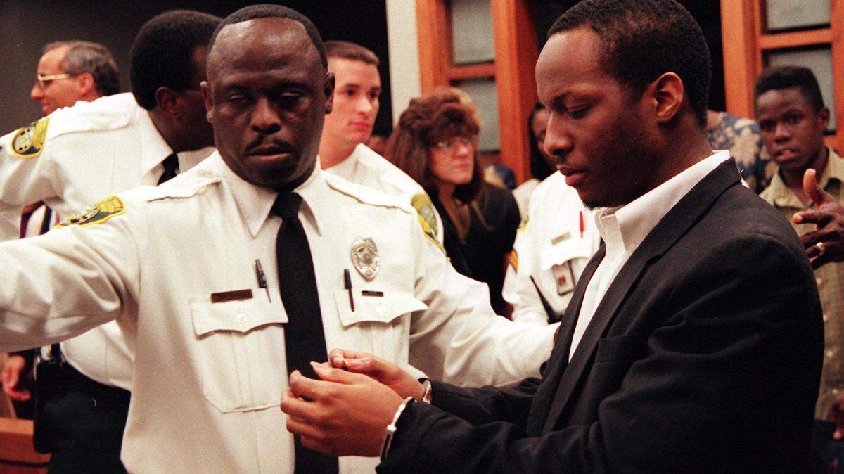 Labrant Dennis stares at the handcuffs while being led away after the reading of the jury's recommendation for the death penalty. He was convicted for the murders of Marlin Barnes and his friend Timwanika Lumpkins in a jealous rage. 