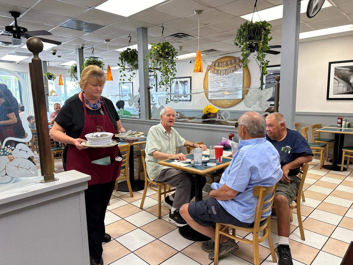 Tonya Gay has worked at Lots of Lox in Palmetto Bay for 26 years. Regular customers, like Mike Foster, left in green shirt, come here for the food, service and daily conversations on all sorts of topics. They are seen here as the afternoon comes to a close near 3 p.m. on April 24, 2024.