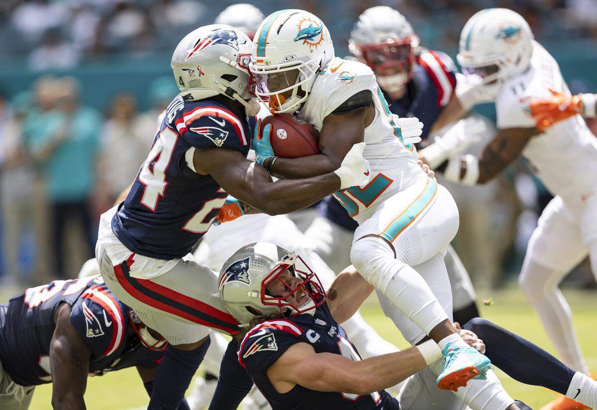 Miami Dolphins wide receiver Dee Eskridge (82) is tackled by New England Patriots safety Dell Pettus (24) in the first half of their NFL game at Hard Rock Stadium on Sunday, Sept. 14, 2025, in Miami Gardens, Fla.