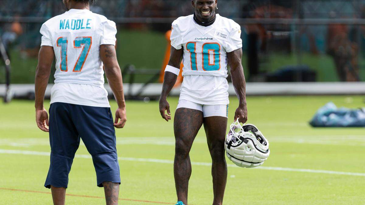 Miami Dolphins wide receivers Tyreek Hill (10) and Jaylen Waddle (17) talk during team practice at the Baptist Health Training Complex on Monday, Aug. 5, 2024, in Miami Gardens, Fla.