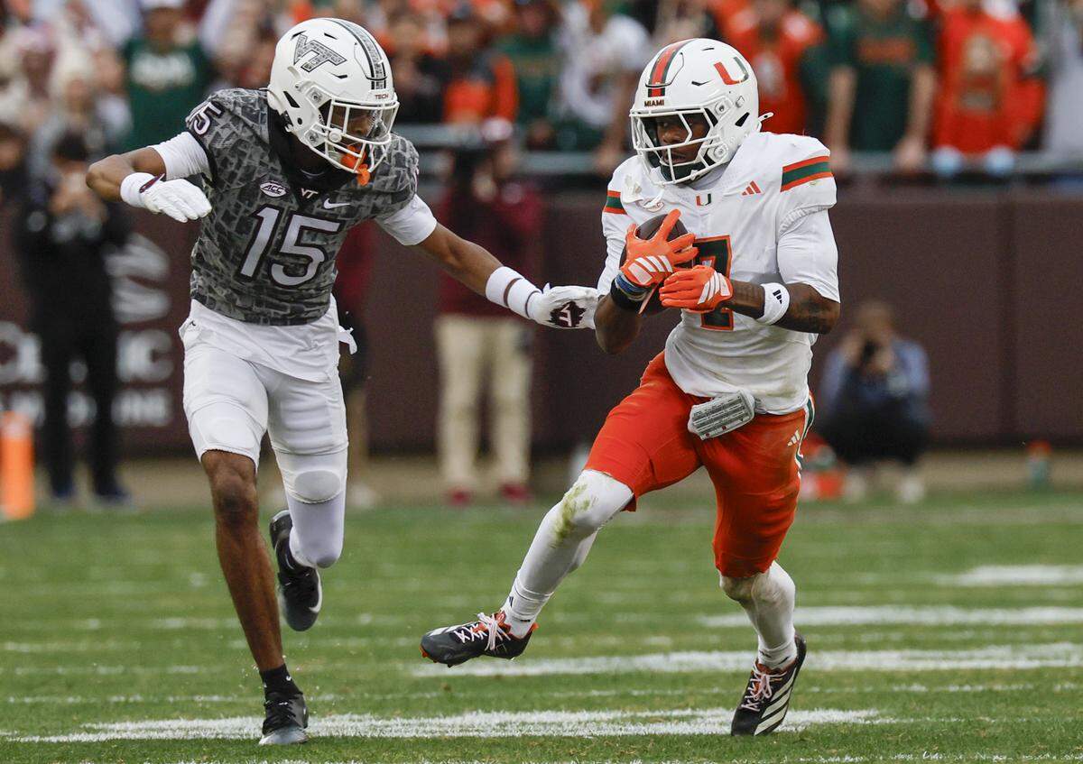 Miami Hurricanes safety Zechariah Poyser (7) recovers a fumble by Virginia Tech Hokies quarterback William Watson III (5) as Virginia Tech Hokies wide receiver Shamarius Peterkin (15) tries to make the stop in the second half at Lane Stadium in Blacksburg, Virginia, on Saturday, November 22, 2025.