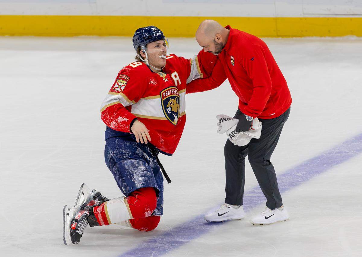 Florida Panthers left-wing Matthew Tkachuk (19) is helped off the ice by a team trainer after being injured from a hit by Tampa Bay Lightning right-wing Nikita Kucherov (86) during the first period of an NHL game at Amerant Bank Arena on Monday, Dec. 23, 2024, in Sunrise, Florida.