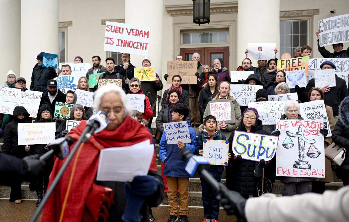 Supporters for Subramanyam ‘Subu’ Vedam hold posters as Saraswathi Vedam talks about seeking justice for her brother before his Post-Conviction Relief Act hearing on Thursday, Feb. 6, 2025 at the Centre County Courthouse.