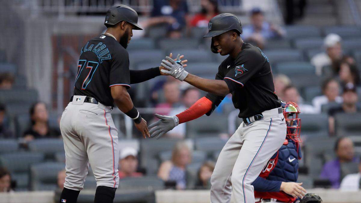 Miami Marlins’ Jesus Sanchez, right, celebrates with Bryan De La Cruz (77) after hitting a two-run home run off Atlanta Braves pitcher Ian Anderson during the first inning of a baseball game Friday, Sept. 10, 2021, in Atlanta. (AP Photo/Ben Margot)