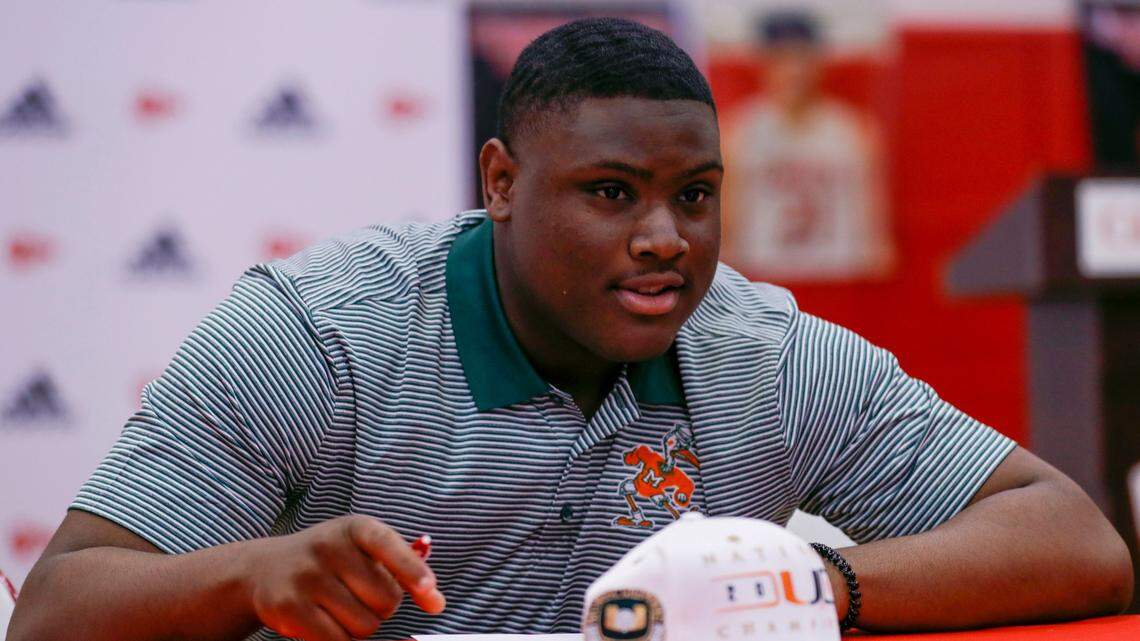 Cardinal Gibbons defensive tackle Ahmad Moten signs his letter of intent to play college football at the University of Miami on National Signing Day during an event at the Cardinal Gibbons High School school gym in Fort Lauderdale, Florida on Wednesday, February 2, 2022.