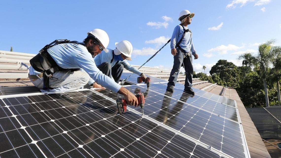 Workers install solar panels at a home in South Miami-Dade on Nov. 13, 2015.