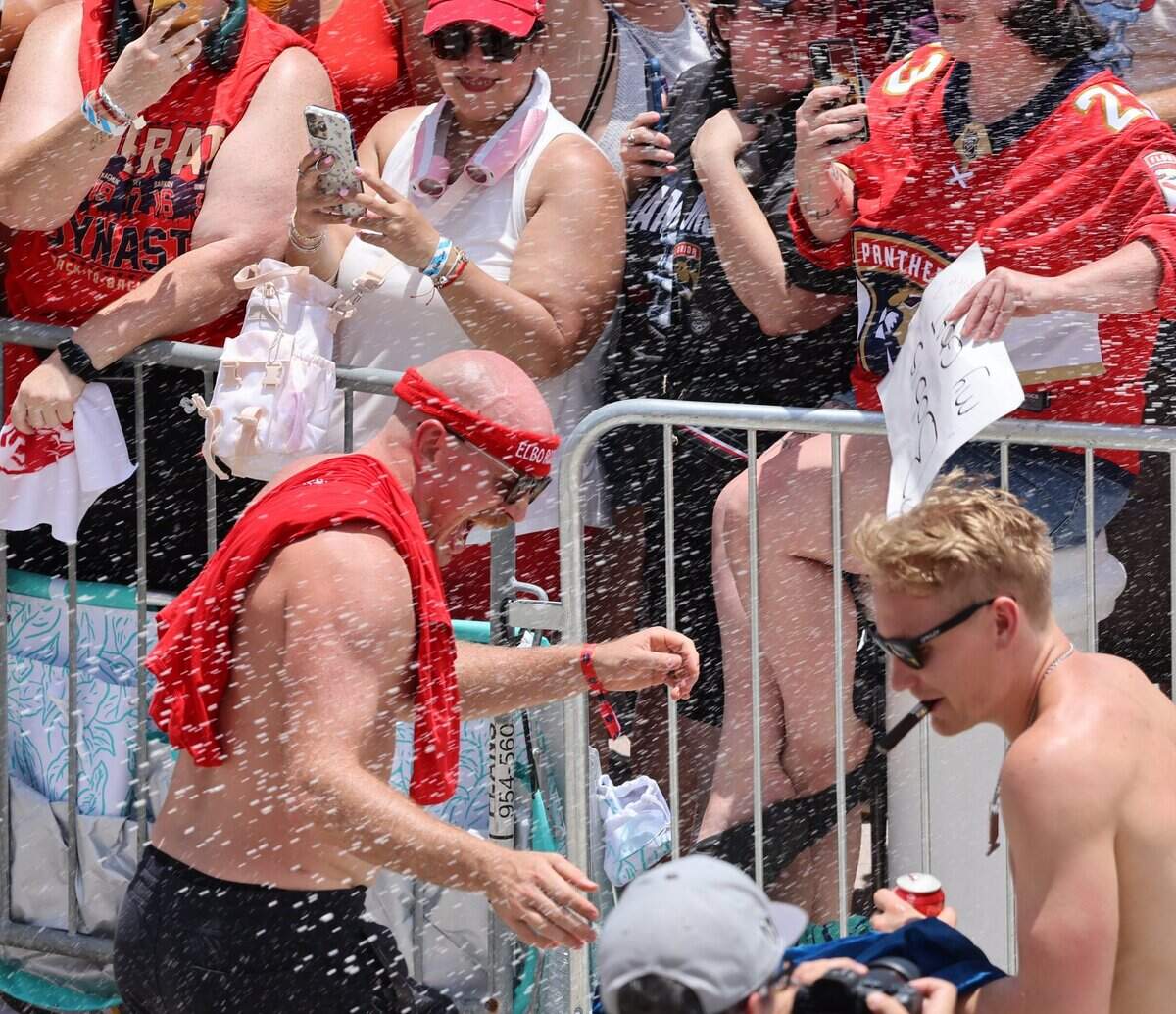 Panthers players Nate Schmidt (88) and Gustav Forsling (42) greet fans and is showered with sparkling wine on A1A just north of the staging area for the Florida Panthers Stanley Cup championship celebration parade on Sunday, June 22, 2025 in Fort Lauderdale, Florida.