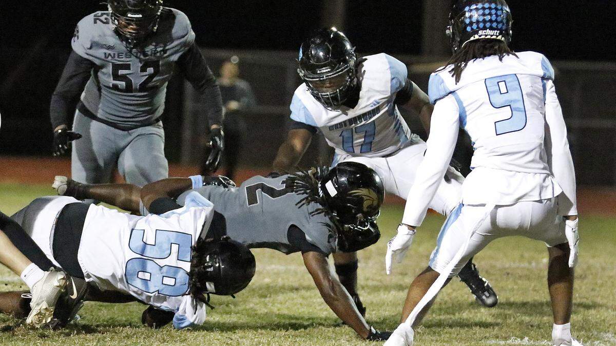West Broward Bobcats Amir Lane (58) tackles Western Wildcats running back Damian Dickenson (2) during the football game on Thursday, October 30, 2025 at Western HS in Davie. Andrew Uloza / for Miami Herald