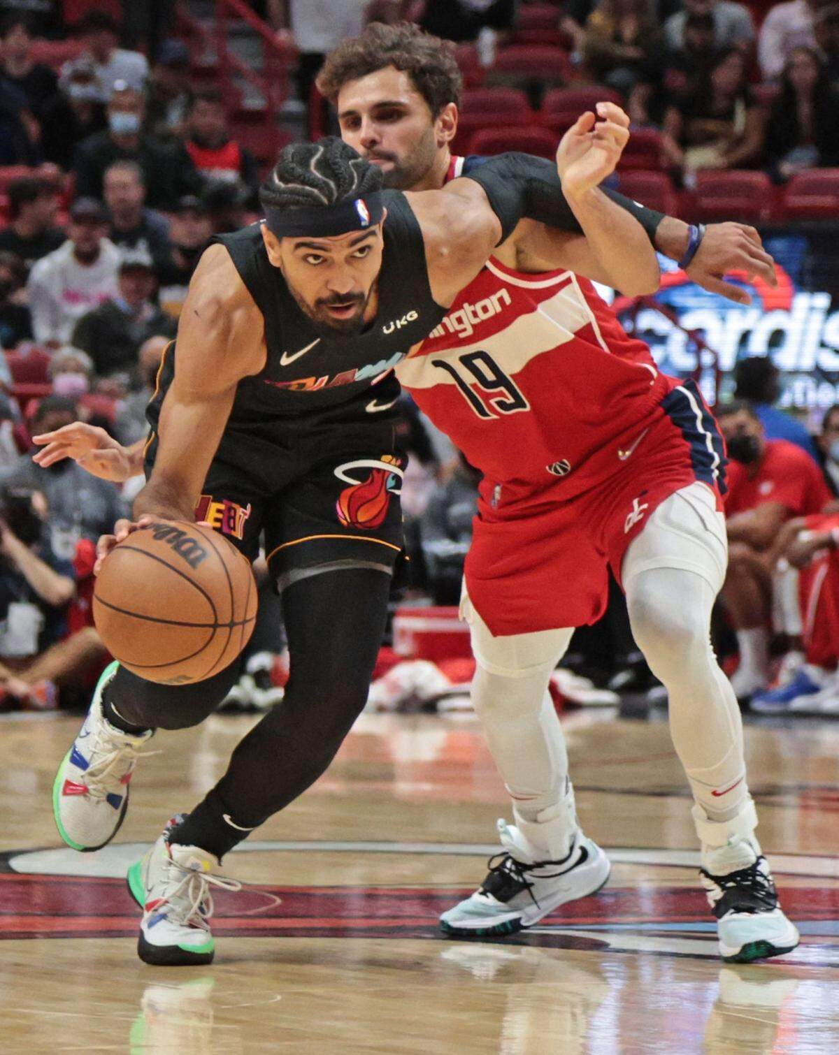 Miami Heat guard Gabe Vincent (2) tangles with Washington Wizards guard Raul Neto (19) in the first half at the FTX Arena in Miami on Thursday, November 18, 2021