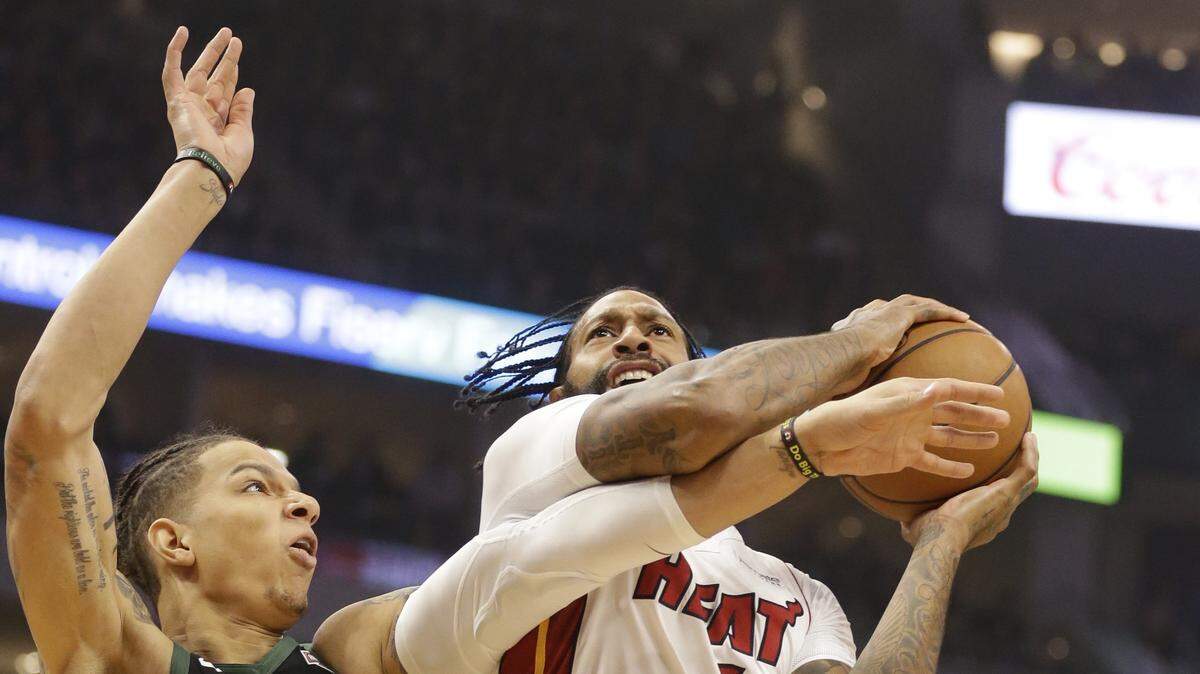 Miami Heat’s James Johnson, right, drives against Milwaukee Bucks’ D. J. Wilson during the first half of an NBA basketball game Friday, March 22, 2019, in Milwaukee. (AP Photo/Jeffrey Phelps)