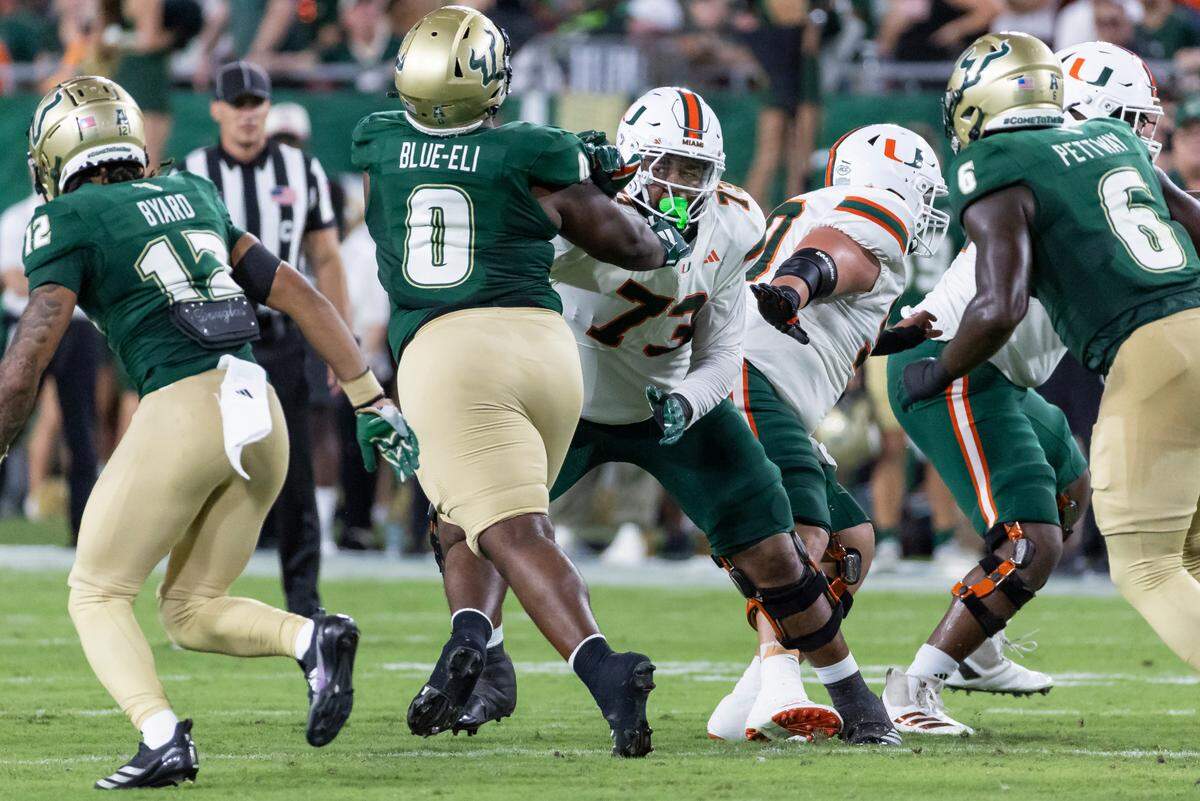 Miami Hurricanes offensive lineman Anez Cooper (73) works to stop South Florida Bulls defensive tackle Doug Blue-Eli (0) in the first half of their NCAA college football game at the Raymond James Stadium on Saturday, Sept. 21, 2024, in Tampa, Fla.
