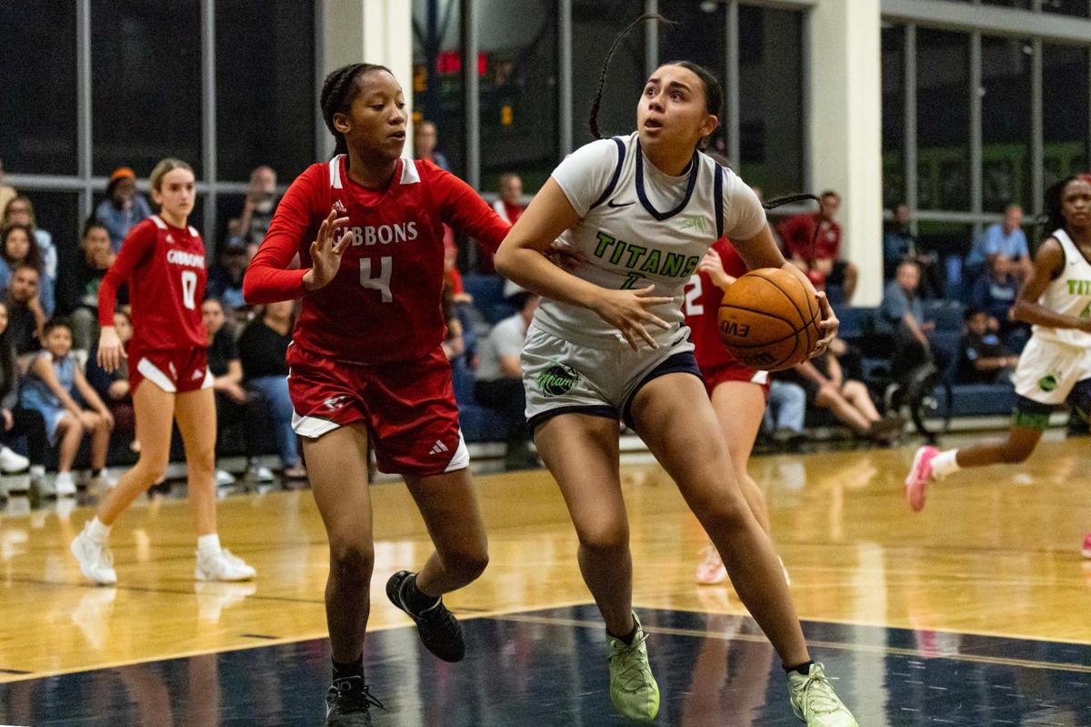 SLAM guard Adaya Montalvo (2) drives toward the rim past Cardinal Gibbons defender Anoya Forgerthy (4) during the girls basketball regional semifinal playoff game on Tuesday, February 18, 2025, in Miami, Florida.