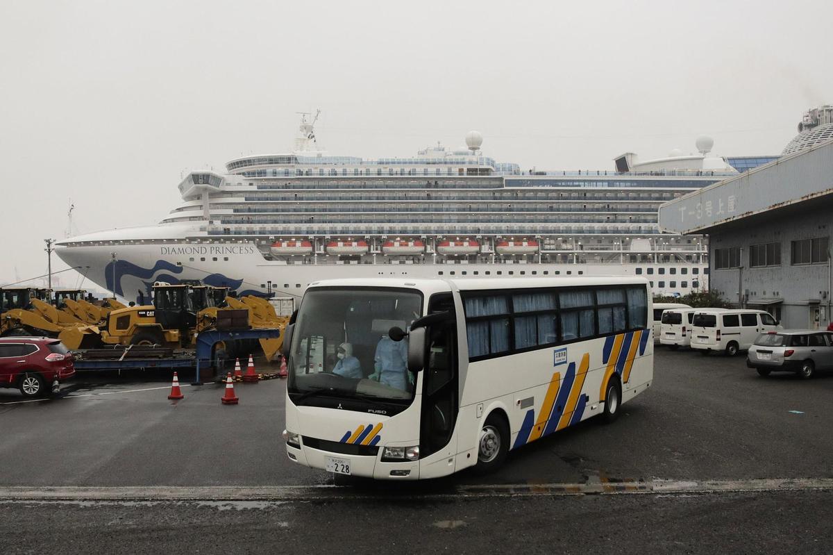 A bus leaves the quarantined Diamond Princess cruise ship at a port Sunday, Feb. 16, 2020, in Yokohama, near Tokyo. The U.S. says Americans aboard a quarantined ship will be flown back home on a chartered flight Sunday, but that they will face another two-week quarantine.