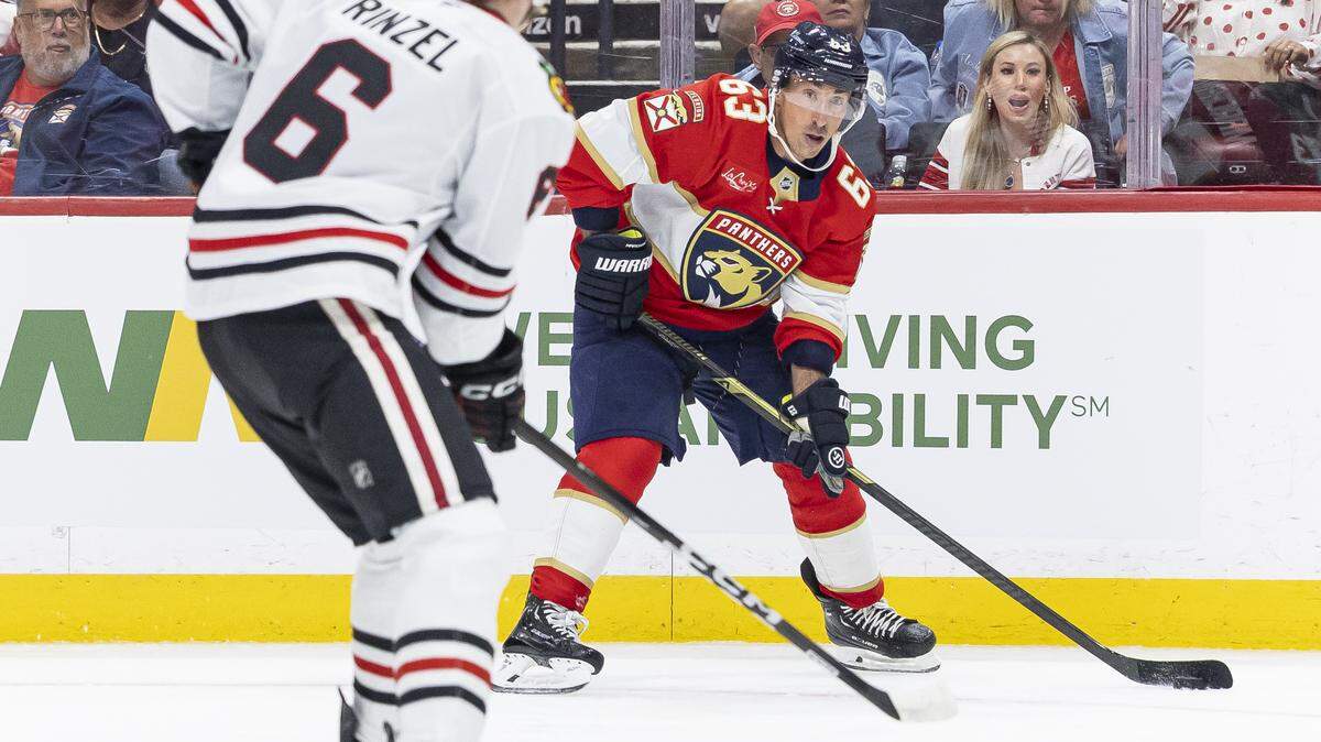 Florida Panthers left wing Brad Marchand (63) looks to pass the puck as Chicago Blackhawks defenseman Sam Rinzel (6) defends in the second period of their NHL game at Amerant Bank Arena on Tuesday, Oct. 7, 2025, in Sunrise, Fla.
