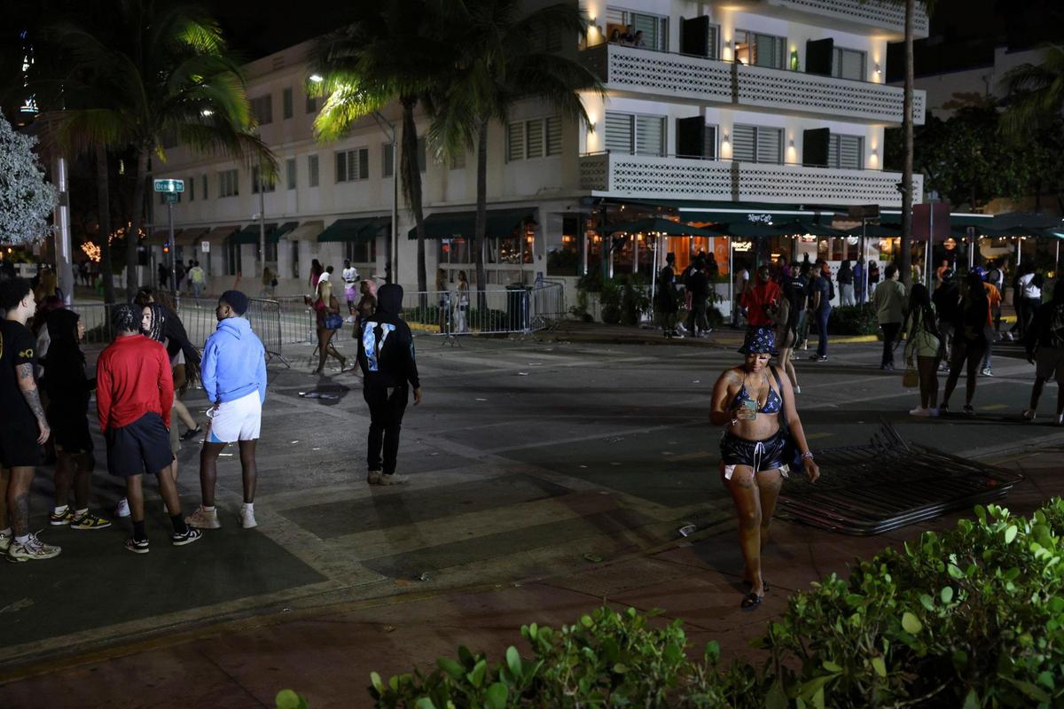 People clear out at Eighth Street and Ocean Drive after an announcement is played reminding people of the 11:59 p.m. curfew during spring break on Sunday, March 19, 2023, in Miami Beach.