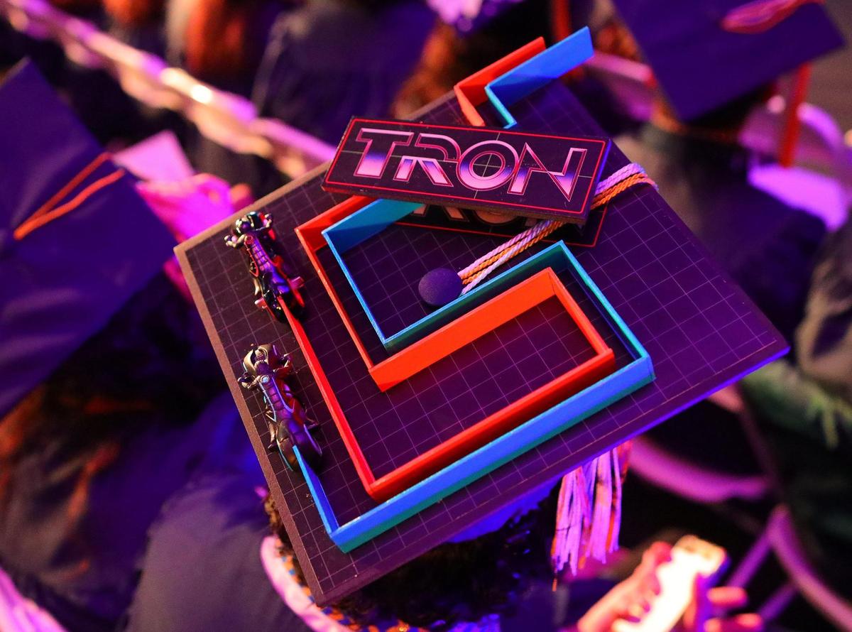 A student flashes a Tron-themed cap at graduation, after the science fiction film about a video game. 