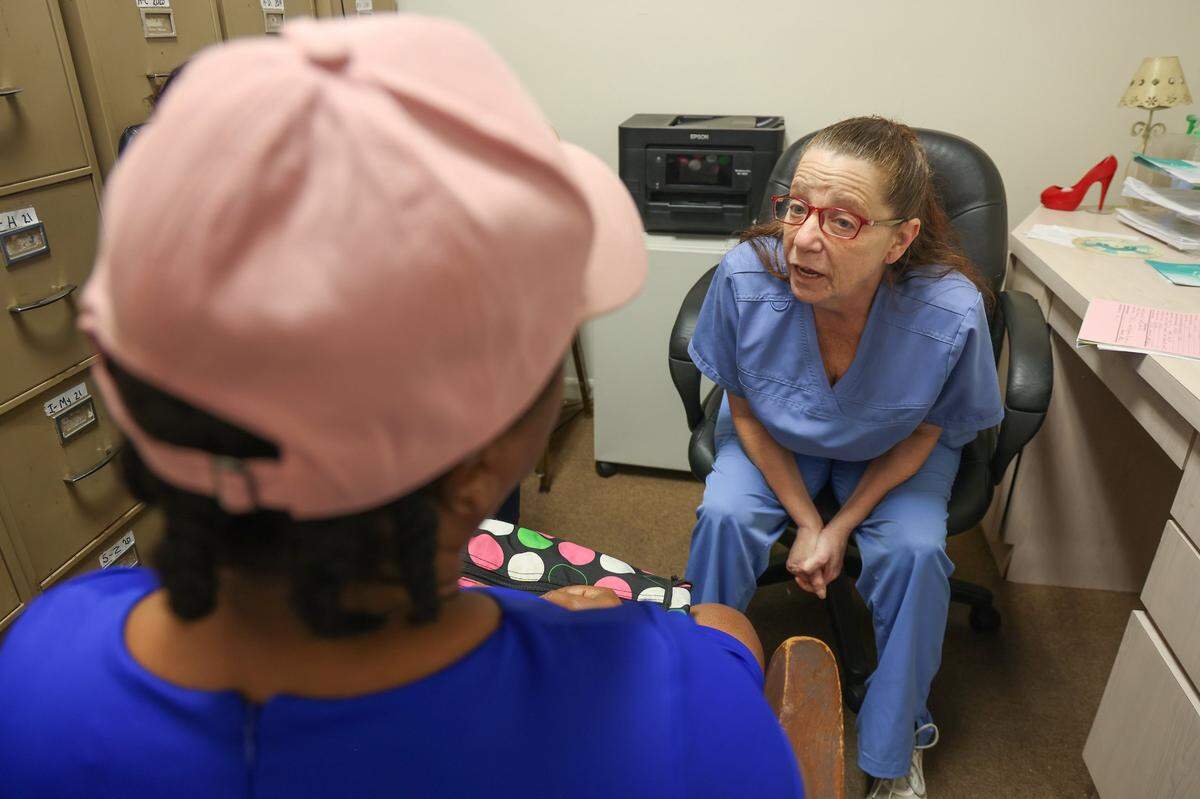 Sherri Loss, right, a LPN who came out of retirement during the pandemic to work at the East Cypress Women’s Center, has a consultation session with a patient during a busy morning at the clinic on Monday, April 24, 2023.