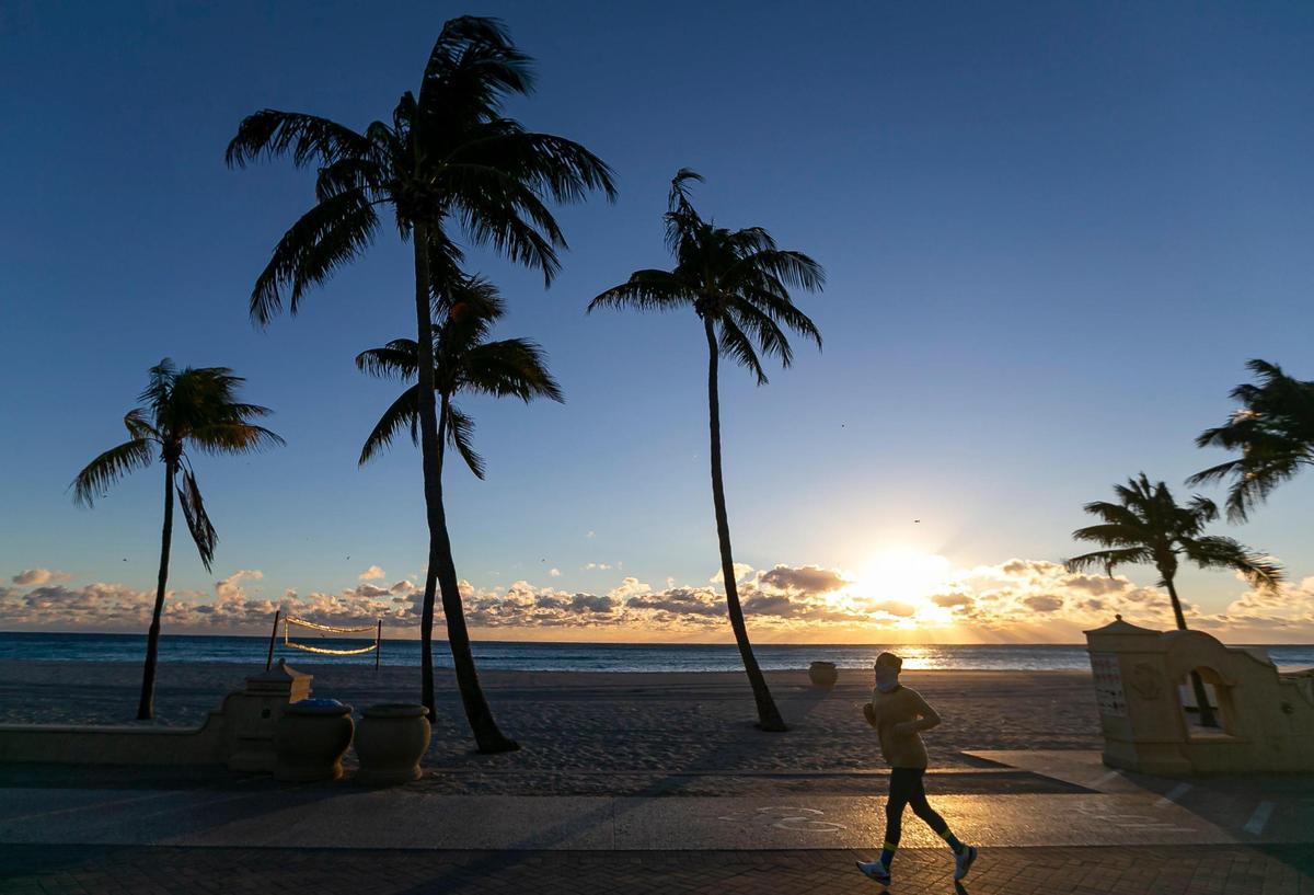 A runner makes her way down the Hollywood Beach Broadwalk as temperatures dip into the mid-40s on Saturday, Jan. 14, 2023, in Hollywood, Florida.