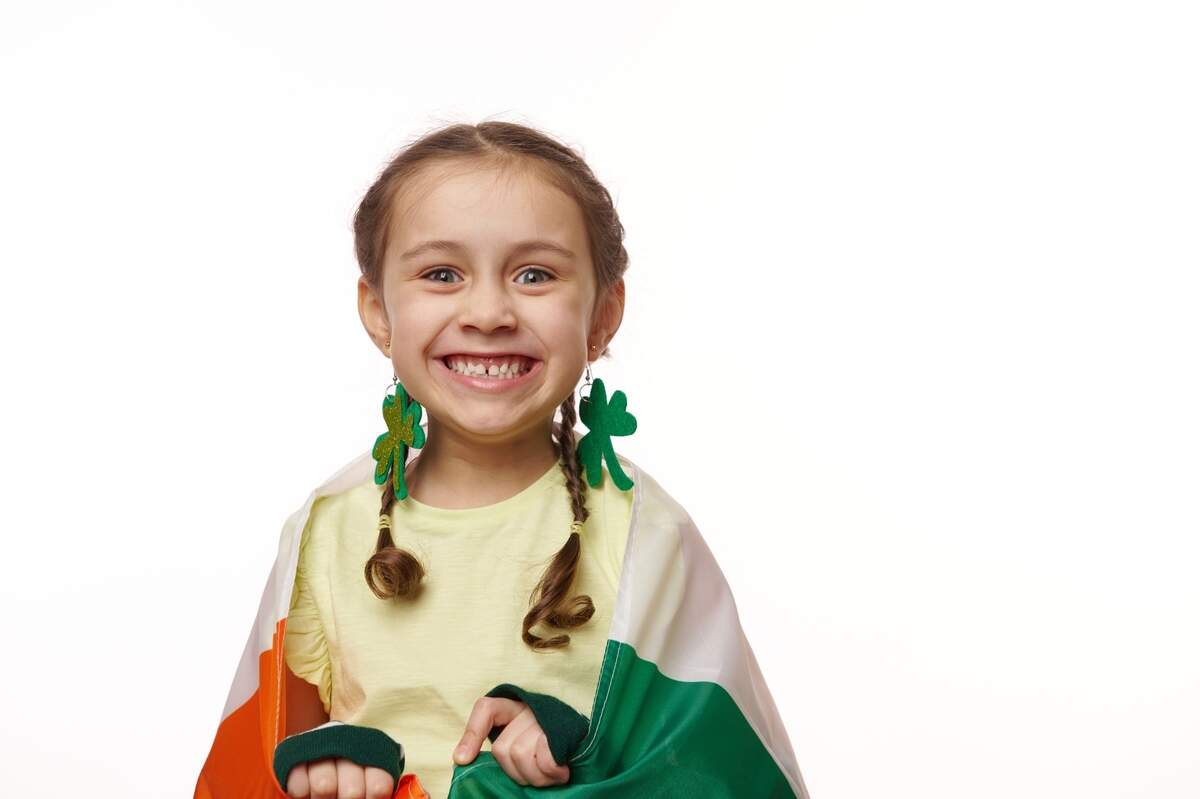 young girl wearing irish flag as a cape