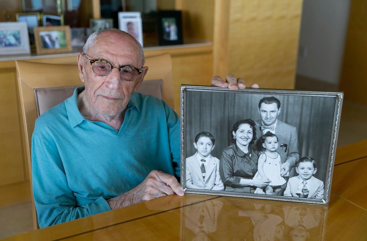 Holocaust survivor Jack Waksal, 97, holds a photo of him, his late wife, Sabina, and their three children while at his apartment in Bal Harbour, Florida on Tuesday, April 26, 2022.