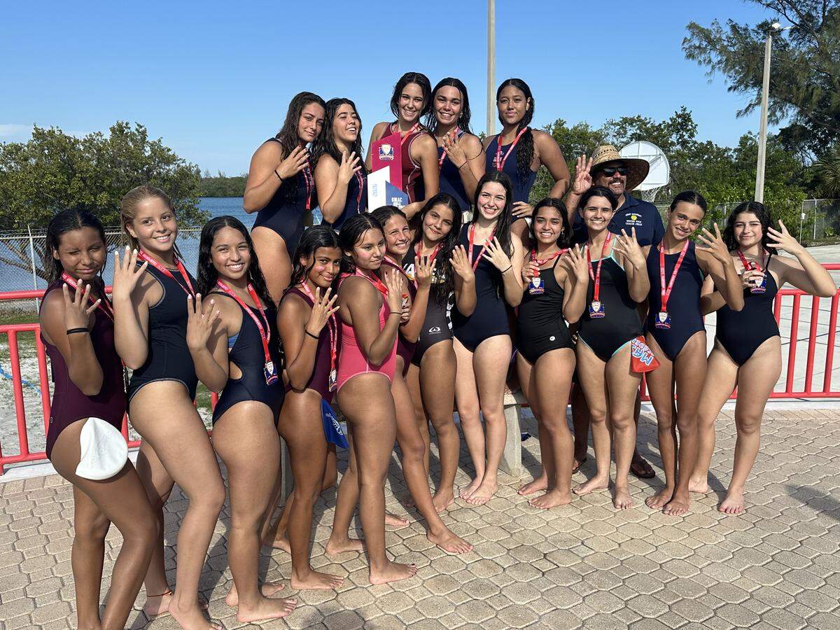 The MAST Academy girls’ water polo team celebrates after winning its fourth consecutive GMAC championship on Monday at the Makos’ home pool.