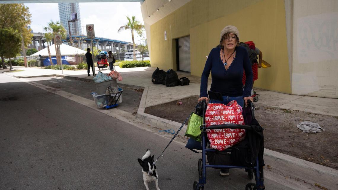 Eli, a veteran, walks with her dog after she and her partner packed up all of their belongings when city of Miami police told them to move and vacate the area on Thursday, Feb. 29, 2024, by the Miami River in downtown Miami.