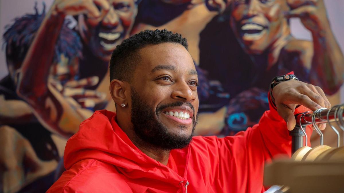 Artist Anthony “Mojo” Reed II, 36, at his solo show at Grand Opening Gallery in Wynwood. In the background is one of his pieces entitled “OVERtown: Brothahood.”