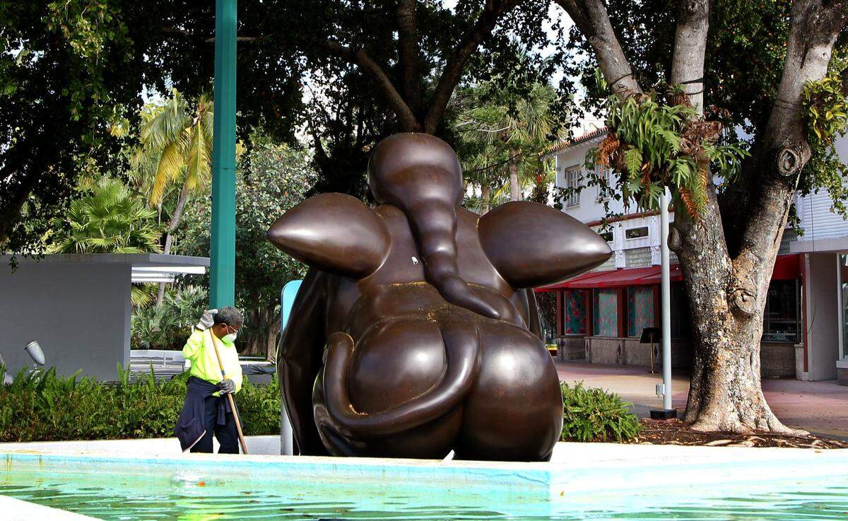A city employee cleans around an sculpture by Colombian artist Fernando Botero on Lincoln Road in Miami Beach.