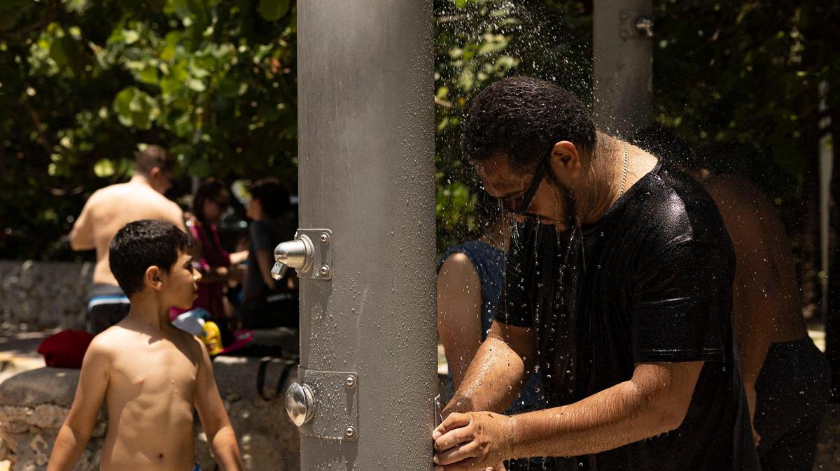 A man rinses off with his family during a day over 90 degrees on Thursday, July 13, 2023, in South Beach.