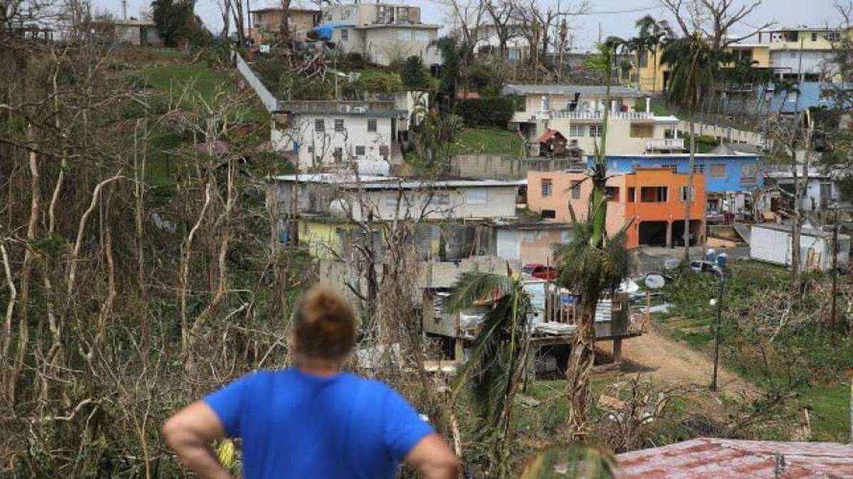 A resident of Corozal, Puerto Rico, looks over her neighborhood after Hurricane Maria in September 2017.