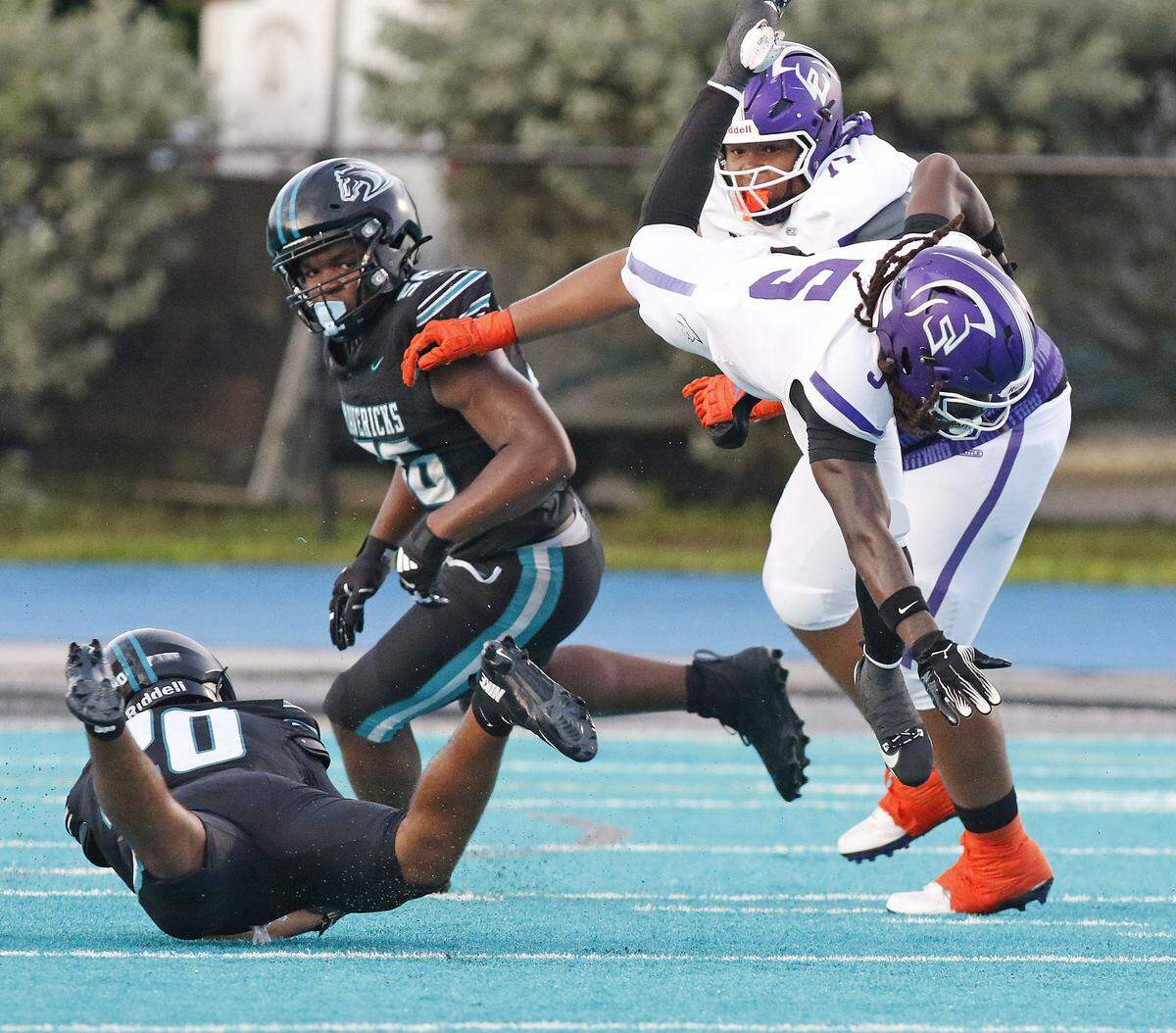 True North Titans running back Cecil Smith (5) goes airborn while trying to escape a tackle by Archbishop McCarthy defenders during the football game on Friday, September 12, 2025 at Archbishop McCarthy HS in Southwest Ranches. Andrew Uloza / for Miami Herald
