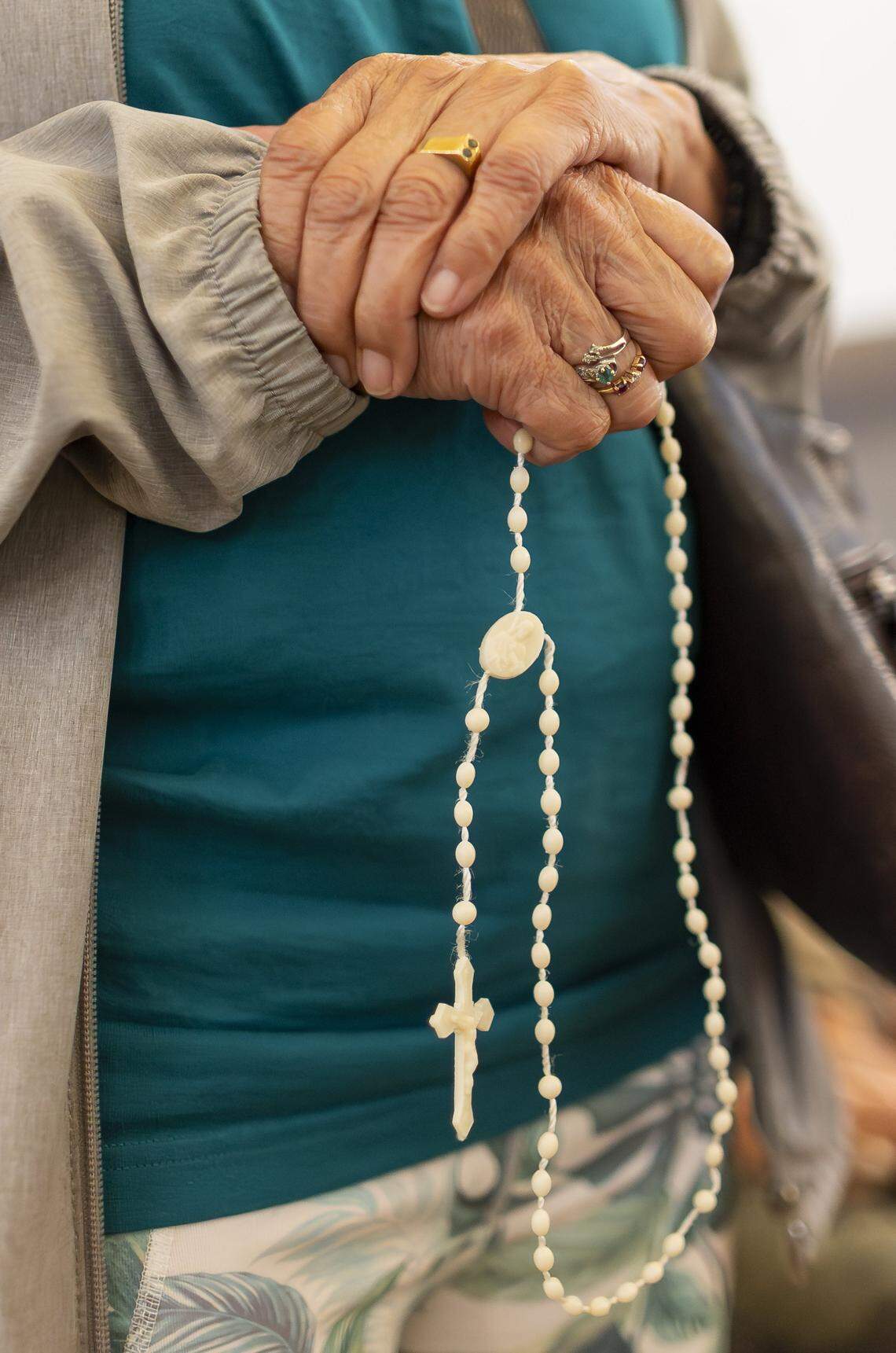 Francia Cardona holds a rosary as she prays during a vigil at Christ Lutheran Church on Saturday, Aug. 9, 2025, in Oakland Park, Fla. The vigil brought together immigrant families and others supporting loved ones in migrant detention centers, such as Alligator Alcatraz, across the state and country.