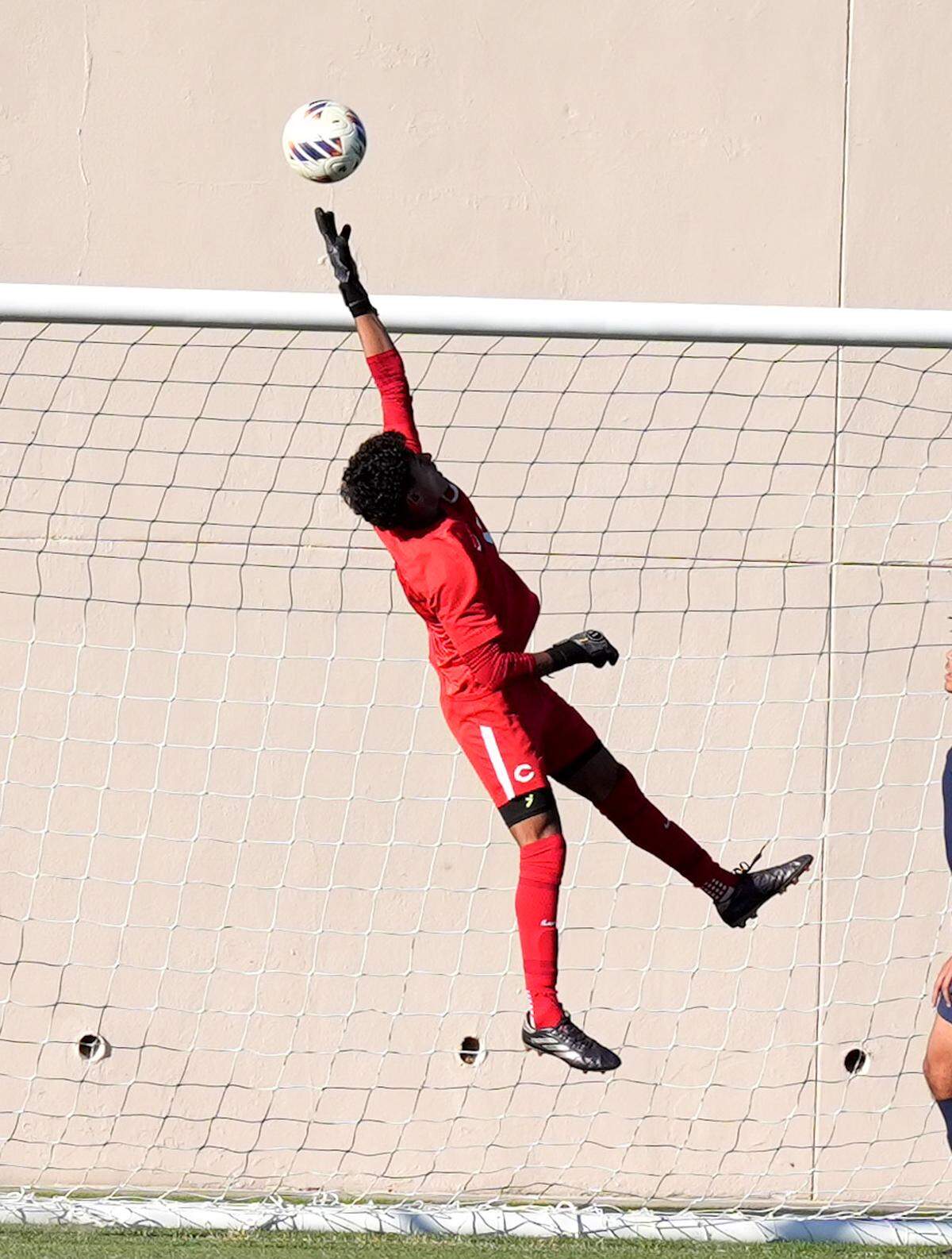 Columbus goalie Nicholas Siman goes up high to make a save during Tuesday’s win over Windermere in a Class 7A state semifinal at SpecMartin Stadium in DeLand, Fla.