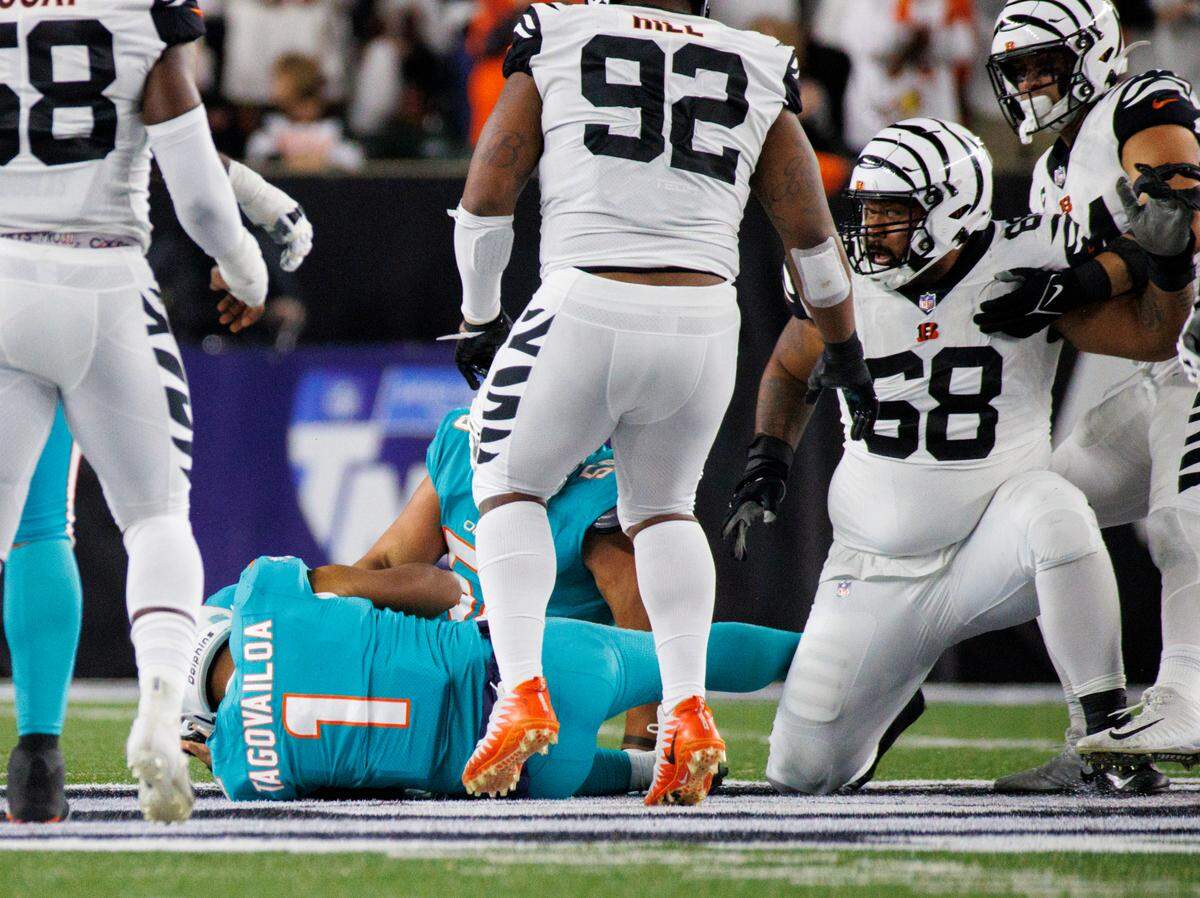 El quarterback de los Miami Dolphins, Tua Tagovailoa (1), cae al suelo después de ser capturado atrás de la línea por Josh Tupou (68), de los Bengals, durante el segundo cuarto, el jueves 29 de septiembre de 2022, en Cincinnati. Tagovailoa dejó el juego, fue brevemente hospitalizado y ahora está bajo los protocolos de conmoción cerebral de la NFL.