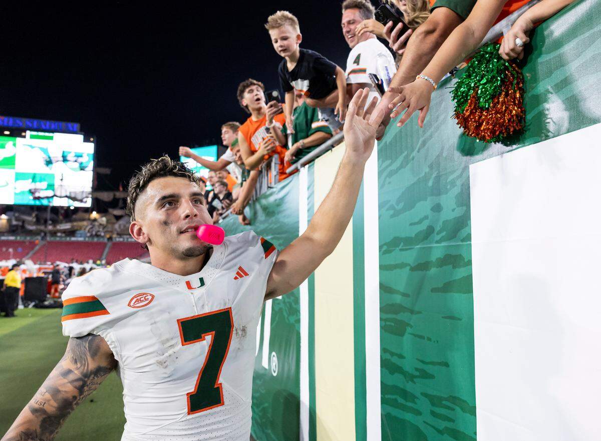 Miami Hurricanes wide receiver Xavier Restrepo (7) high fives fans after defeating the South Florida Bulls in their NCAA college football game at the Raymond James Stadium on Saturday, Sept. 21, 2024, in Tampa, Fla.