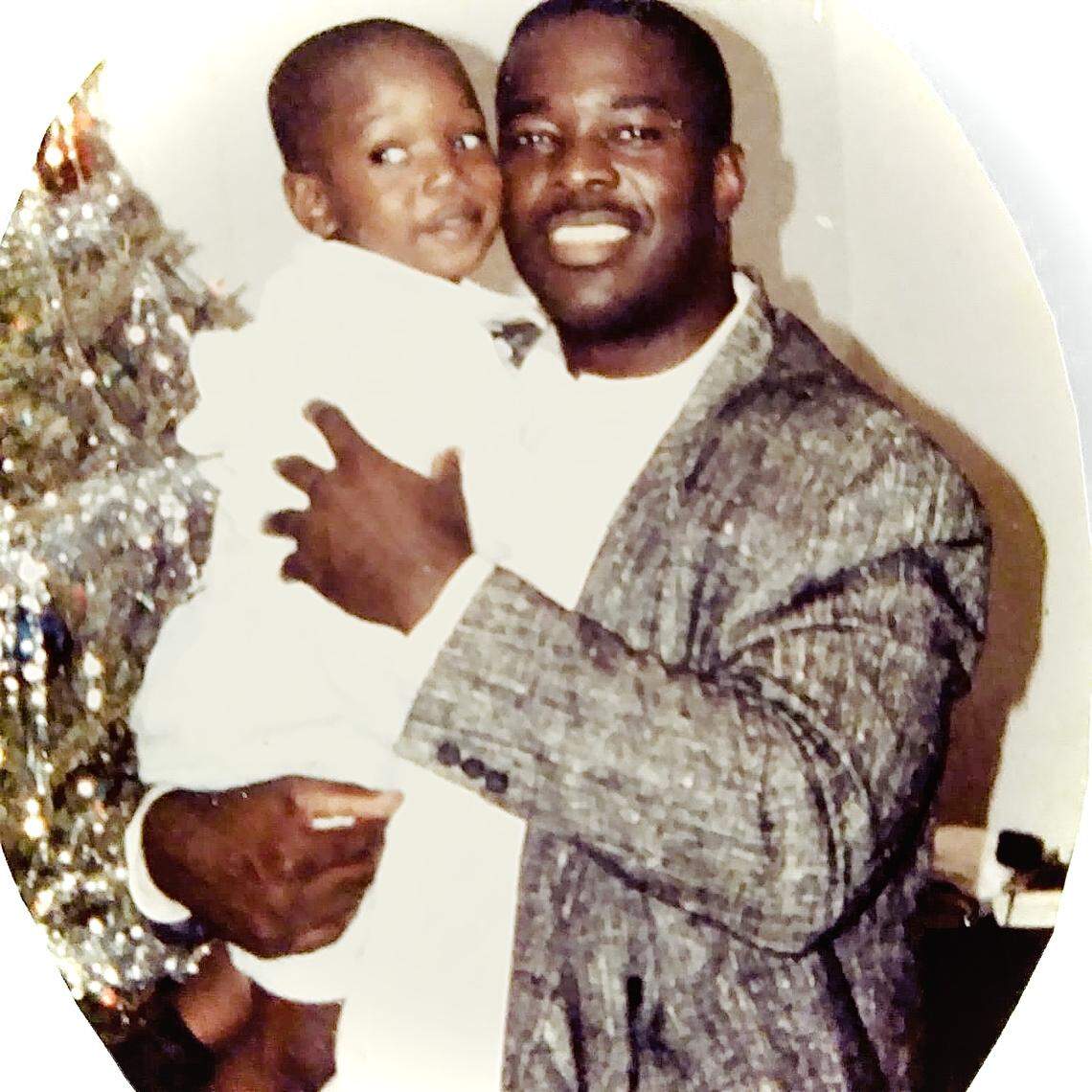 Miami Northwestern High principal Wallace Aristide, a former Miami-Dade football coach, is shown holding his son Ishmael in an old family photo. Ishmael, now 30, was named the Miami Hurricanes outside linebackers coach in February 2021.