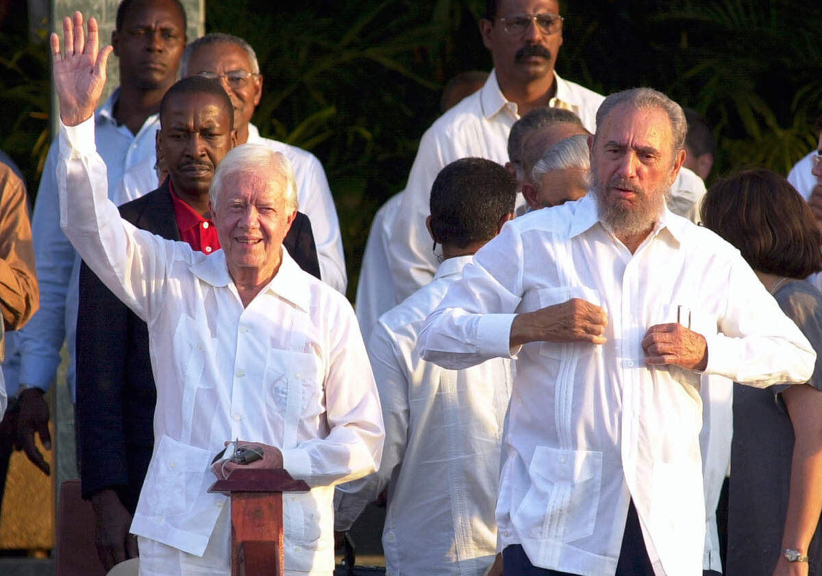 Former U.S. President Jimmy Carter, left, and Cuban President Fidel Castro are seen in this May 13, 2002 photo, both wearing traditional guayabera. The guayabera, the boxy, pleated shirt is experiencing a revival in the tattered workshops of Cuban fashion designers and state-run clothiers.