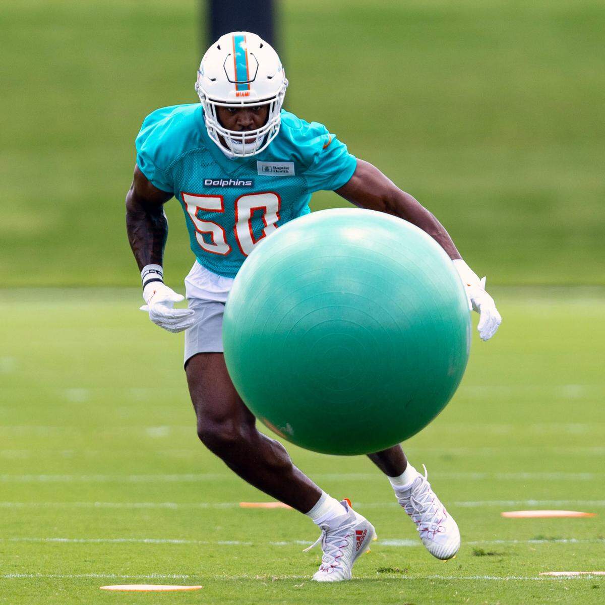 Rookie linebacker Mitchell Agude (50) runs through tackling drills during 2023 Miami Dolphins Rookie Minicamp practice at Baptist Health Training Complex in Miami Gardens, Florida, on Friday, May 12, 2023.