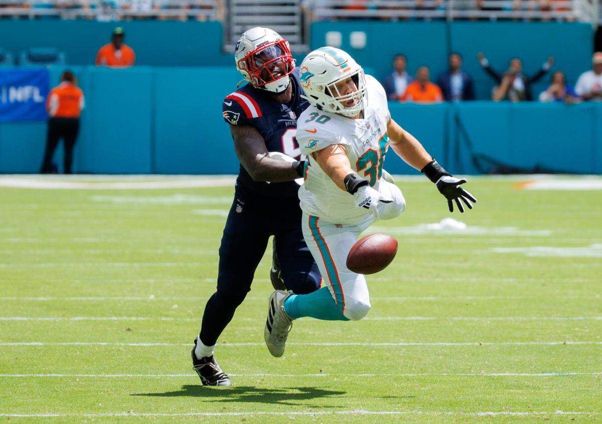 Miami Dolphins fullback Alec Ingold (30) is unable to catch a pass against the defense of New England Patriots linebacker Ja’Whaun Bentley (8) during first quarter of an NFL football game at Hard Rock Stadium on Sunday, September 11, 2022 in Miami Gardens, Florida.