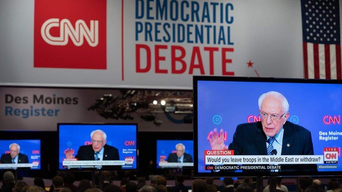 Screens display presidential hopeful Vermont Senator Bernie Sanders in the spin room during the seventh Democratic primary debate of the 2020 presidential campaign in Des Moines, Iowa.