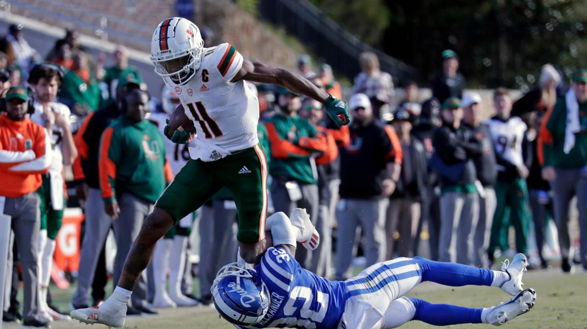 Miami wide receiver Charleston Rambo (11) gets hit by Duke safety Jalen Alexander (32) as he runs upfield during the second half of an NCAA college football game Saturday, Nov. 27, 2021, in Durham, N.C. (AP Photo/Chris Seward)